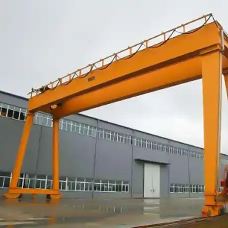 Shipyard gantry crane with extended boom lifting ship sections